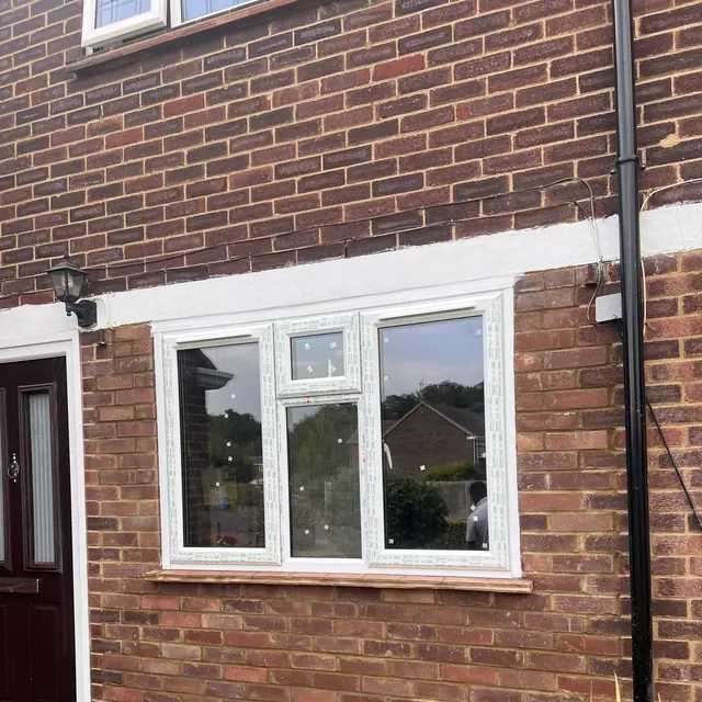 Newly fitted white uPVC window in the brick wall of a house